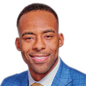 Headshot of a man named Victor Demesmin Jr., with a warm smile, wearing a blue patterned suit and gold tie, radiating professionalism and approachability.