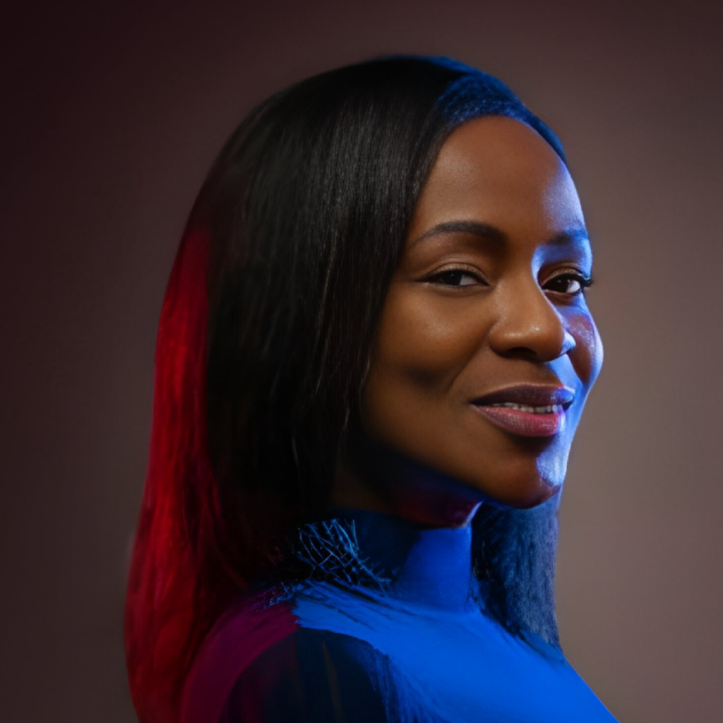 Portrait of Rose Lubin, a confident woman with smooth dark skin and long black hair, wearing a dark top. The image features dynamic lighting with blue and red tones highlighting one side of her face and hair, creating a striking contrast against the dark background.