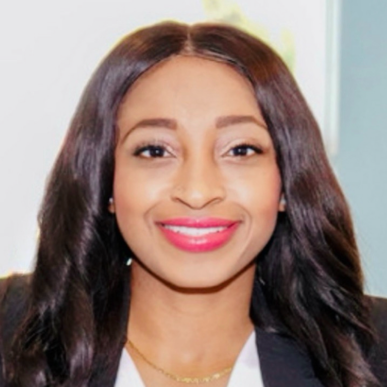 A professional headshot of Dr. Sandy Juste, MD, MSc, with long, dark hair, smiling, and wearing a white top and blazer.